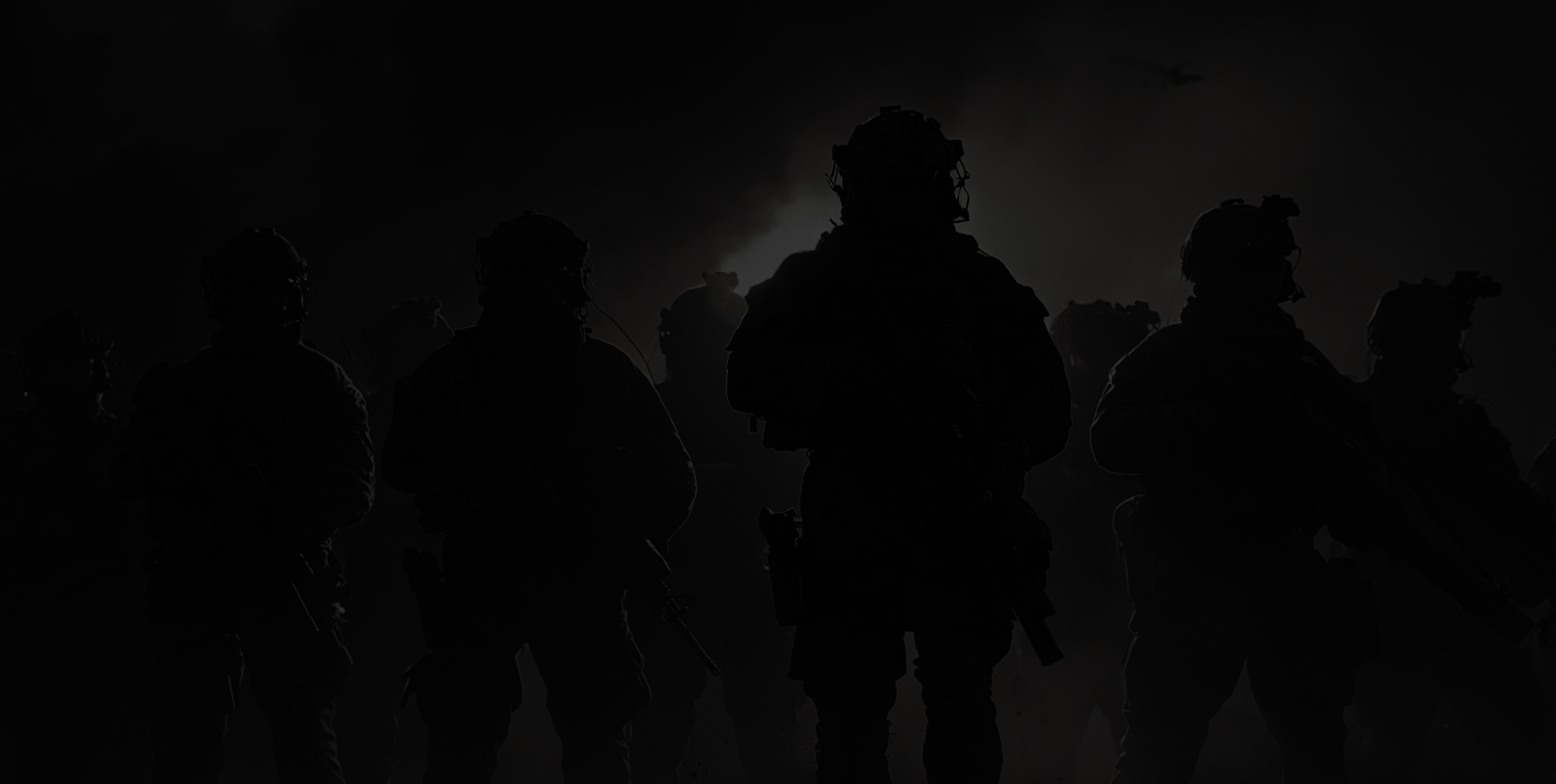 A squad in silhouette against a smoke-lit sky